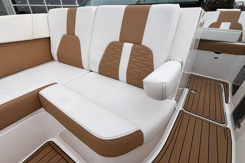 Slide: The Image of 2022 MasterCraft X26 boat interior with white and tan seating, teak flooring. - 55