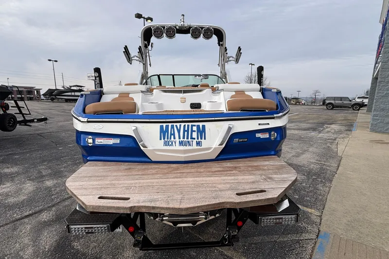 Slide: The Image of 2022 MasterCraft X26 boat with "MAYHEM" license plate, parked in a lot. - 56