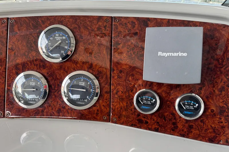 Slide: The Image of Dashboard of a 2005 Formula 400 Super Sport with gauges and Raymarine display. - 19