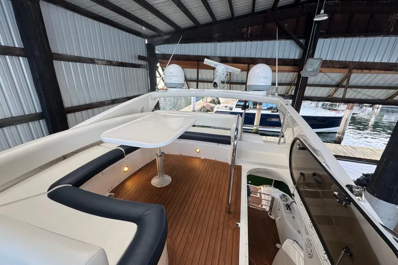 Slide: The Image of Flybridge of 2006 Sunseeker Manhattan 50 yacht with seating and table under a covered dock. - 5