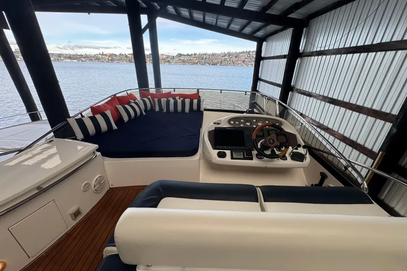 Slide: The Image of 2006 Sunseeker Manhattan 50 yacht helm with seating, docked under a covered area. - 6