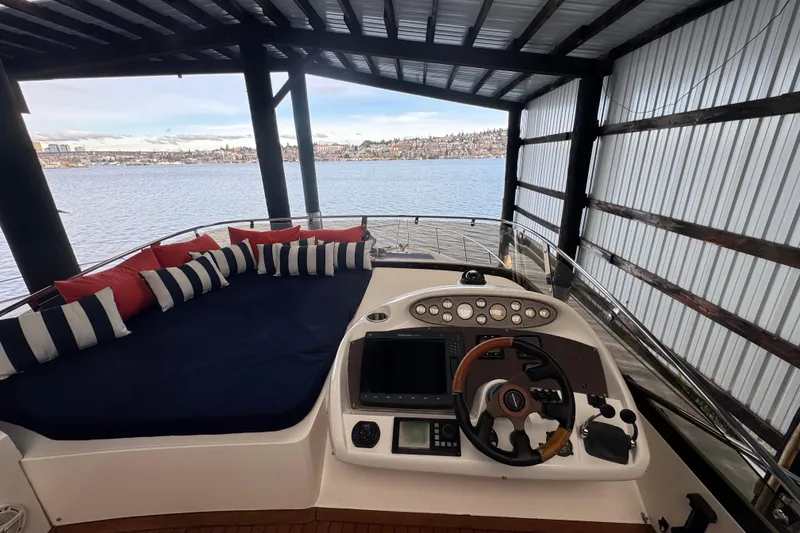 Slide: The Image of 2006 Sunseeker Manhattan 50 yacht helm with striped cushions, docked by the water. - 7