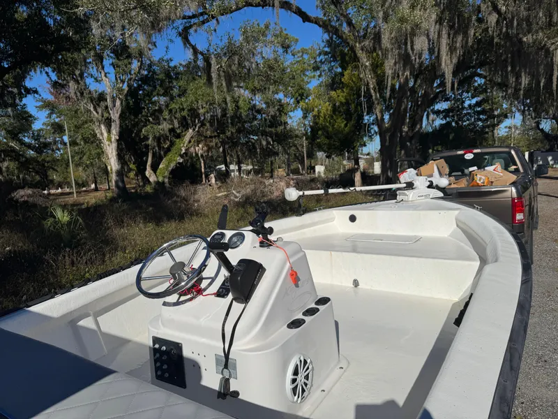 Slide: The Image of 2006 Key Largo 174 boat with steering console, parked near trees and a truck. - 11