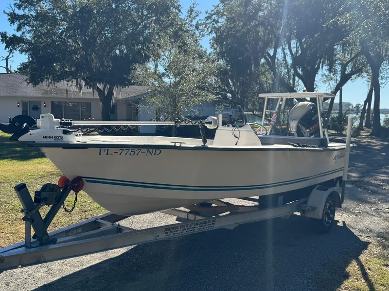 Slide: The Image of 2006 Key Largo 174 boat on trailer, parked outdoors in a sunny residential area. - 2