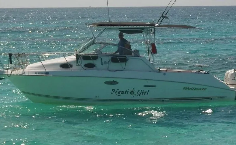 The Image of 2001 Wellcraft 270 Coastal O/B boat on turquoise water, side view. - 0