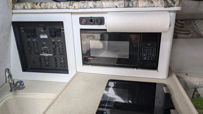 Slide: The Image of 2001 Wellcraft 270 Coastal O/B interior with microwave and control panel. - 13