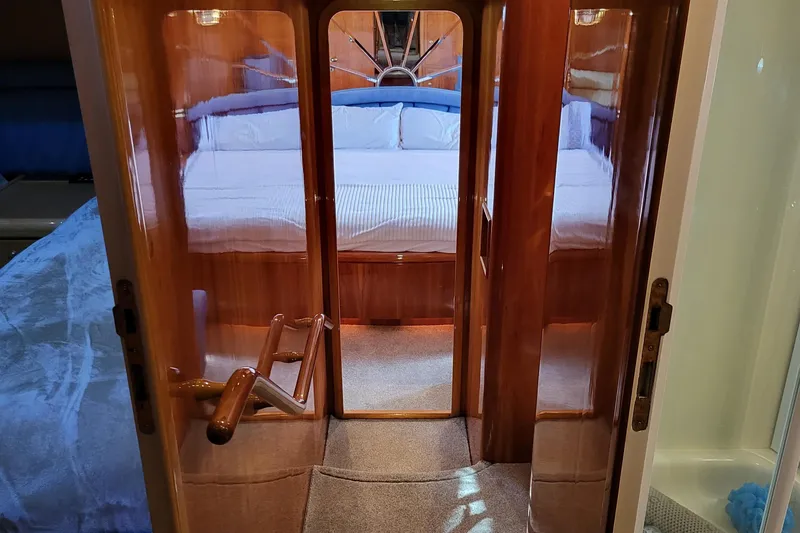 Slide: The Image of Luxurious cabin interior of 2000 Horizon 74 Motor Yacht with wooden finishes and cozy bedding. - 34