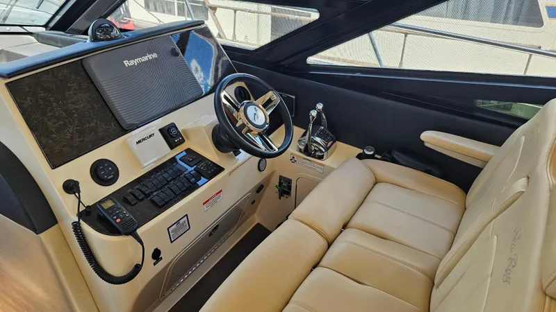 Slide: The Image of 2016 Sea Ray 470 Sundancer helm with beige leather seating and advanced navigation controls. - 12