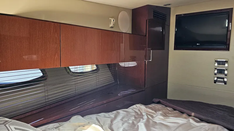 Slide: The Image of Interior cabin of 2016 Sea Ray 470 Sundancer with wood cabinetry and a mounted TV. - 21
