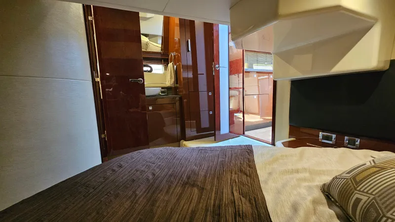 Slide: The Image of Interior cabin of 2016 Sea Ray 470 Sundancer yacht, featuring luxurious bedding and wood finishes. - 25