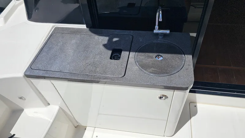 Slide: The Image of 2016 Sea Ray 470 Sundancer outdoor kitchenette with sink and countertop. - 30