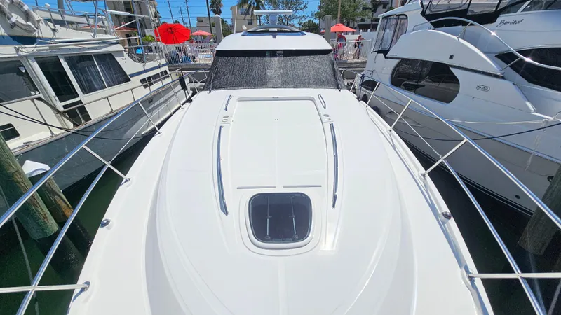 Slide: The Image of 2016 Sea Ray 470 Sundancer yacht docked between boats. - 38