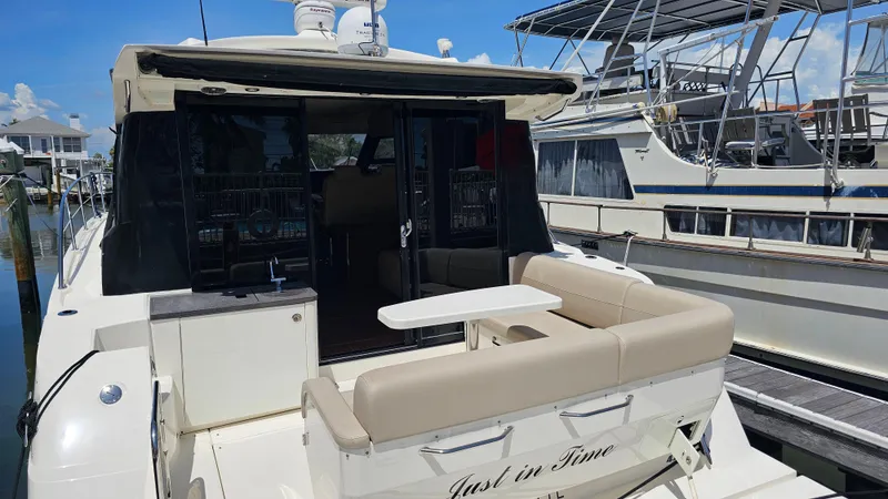 Slide: The Image of 2016 Sea Ray 470 Sundancer yacht docked, featuring a spacious rear seating area. - 39