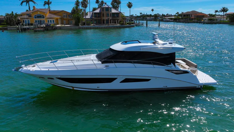 Slide: The Image of 2016 Sea Ray 470 Sundancer yacht cruising on a sunny day near waterfront homes. - 9