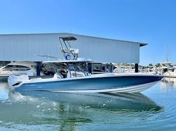 Slide: The Image of 2020 Nor-Tech 390 Sport Center Console boat docked, featuring a sleek design and fishing tower. - 2