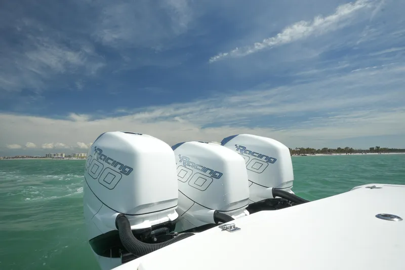 Slide: The Image of 2020 Nor-Tech 390 Sport Center Console with triple outboard engines on open water. - 21