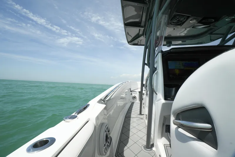 Slide: The Image of 2020 Nor-Tech 390 Sport Center Console with triple outboard engines on open water. - 22