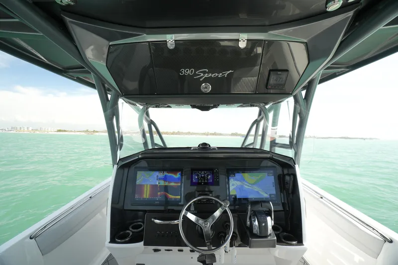 Slide: The Image of 2020 Nor-Tech 390 Sport Center Console boat interior with cushioned seating and ocean view. - 31
