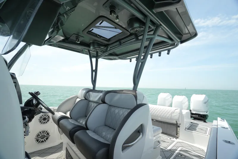 Slide: The Image of 2020 Nor-Tech 390 Sport Center Console dashboard with advanced navigation systems on open water. - 32