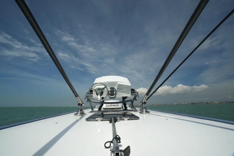 Slide: The Image of 2020 Nor-Tech 390 Sport Center Console boat interior with white quilted seating under blue sky. - 39