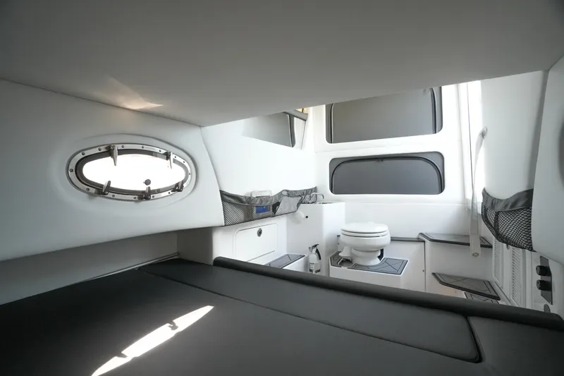 Slide: The Image of 2020 Nor-Tech 390 Sport Center Console cabin interior with sleek black seating and portholes. - 51