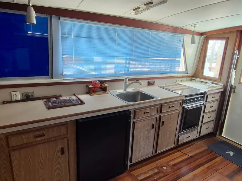 Slide: The Image of Interior of 1982 Bertram 38 Convertible yacht with kitchen, sink, stove, and wooden flooring. - 15