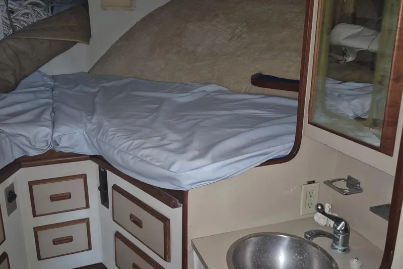Slide: The Image of 1982 Bertram 38 Convertible cabin interior with bed, drawers, and sink. - 18