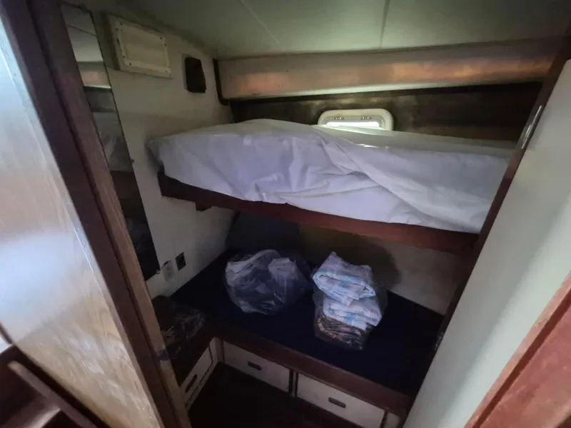 Slide: The Image of 1982 Bertram 38 Convertible cabin with bunk beds and storage drawers. - 19