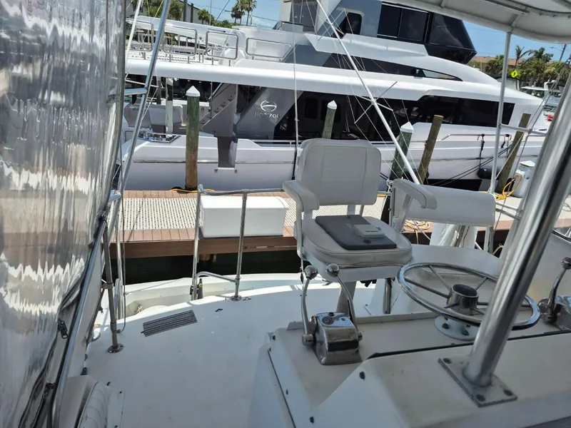 Slide: The Image of 1982 Bertram 38 Convertible yacht cockpit with helm chair and marina view. - 27