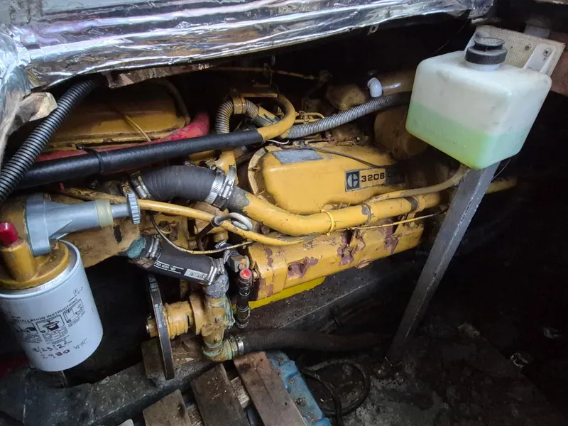 Slide: The Image of Engine compartment of a 1982 Bertram 38 Convertible boat, featuring a Caterpillar 3208 engine. - 38