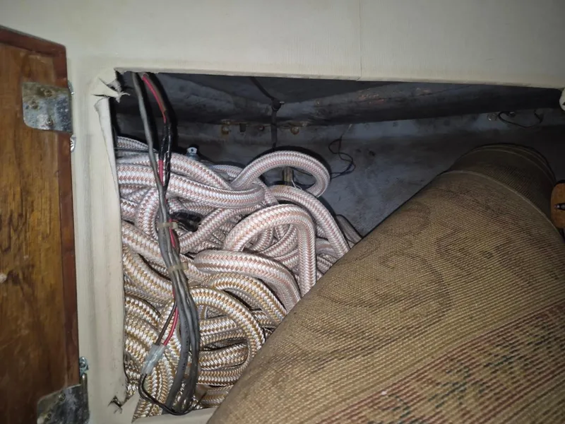 Slide: The Image of Coiled ropes and wires inside a 1982 Bertram 38 Convertible boat compartment. - 40