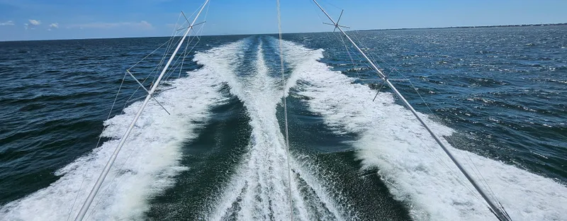 Slide: The Image of Wake trail behind a 1982 Bertram 38 Convertible boat on open water. - 44
