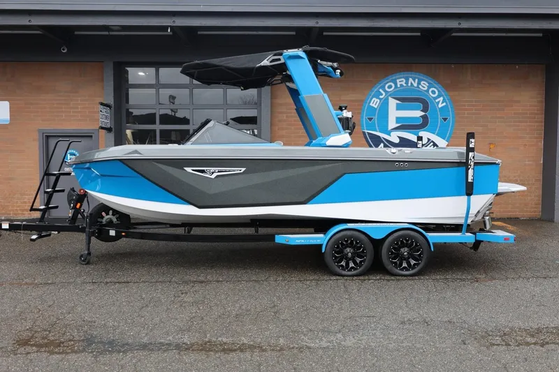 The Image of 2022 Nautique Super Air Nautique S23 boat on trailer, blue and gray design. - 0