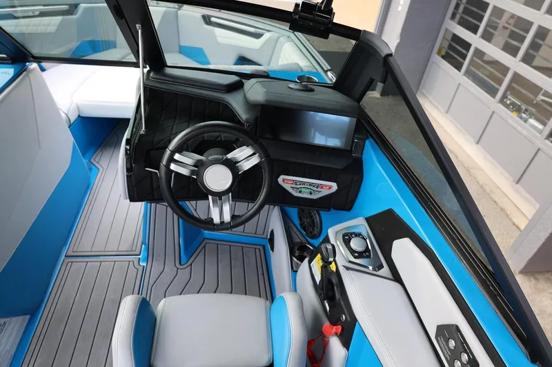 Slide: The Image of 2022 Nautique Super Air Nautique S23 interior seating with gray and blue upholstery. - 26
