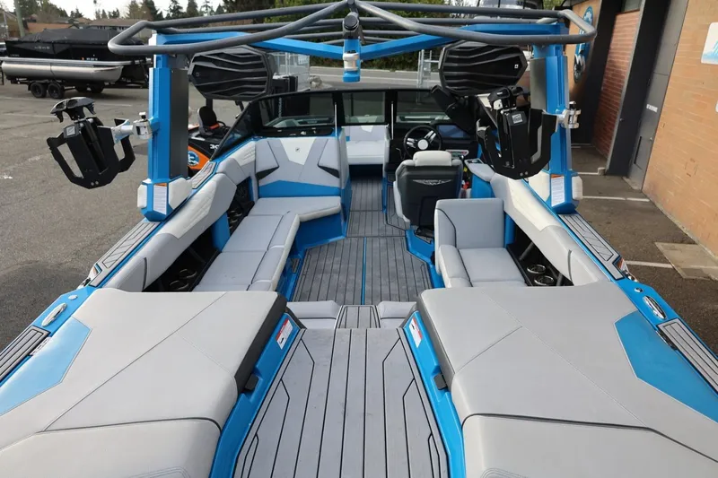 Slide: The Image of 2022 Nautique Super Air Nautique S23 boat with black canopy and blue accents. - 37