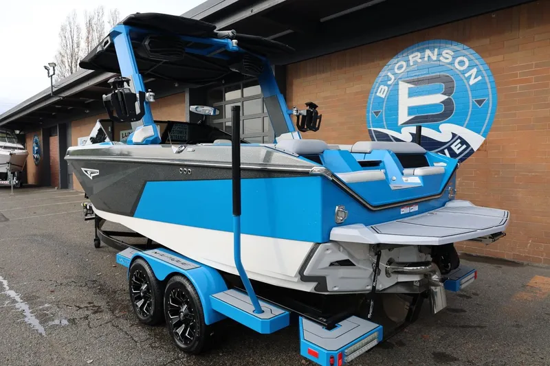 Slide: The Image of 2022 Nautique Super Air Nautique S23 boat, blue, rear view at a marina. - 4