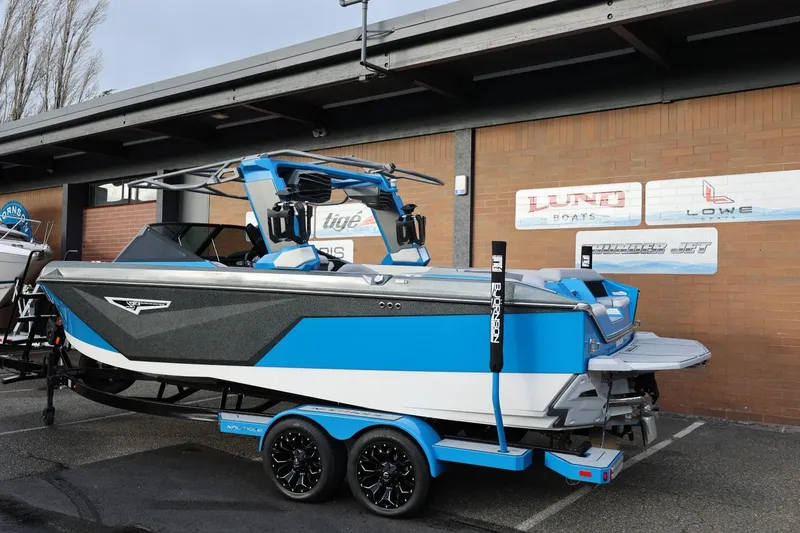 Slide: The Image of 2022 Nautique Super Air Nautique S23 boat in showroom, blue and black exterior. - 47