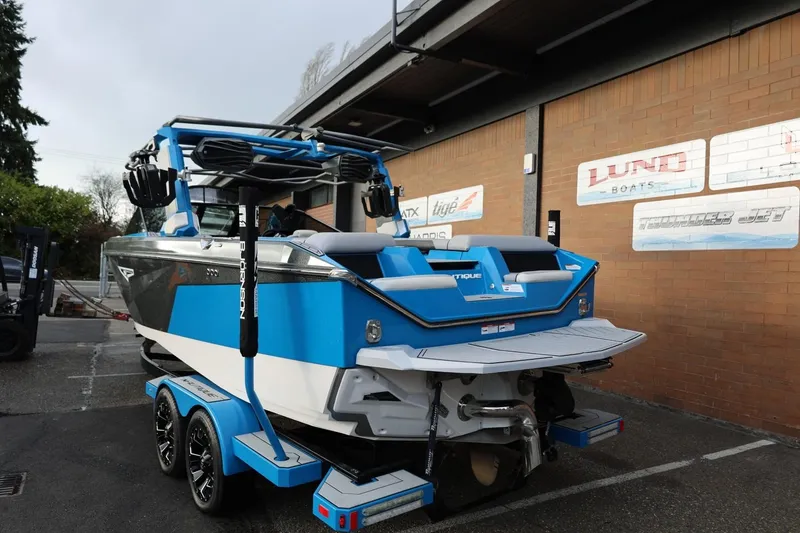 Slide: The Image of 2022 Nautique Super Air Nautique S23 boat in showroom, blue exterior, rear view. - 48