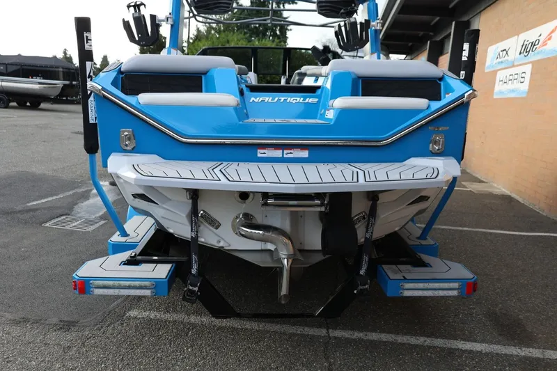 Slide: The Image of 2022 Nautique Super Air Nautique S23 boat in a showroom, featuring blue and white design. - 49