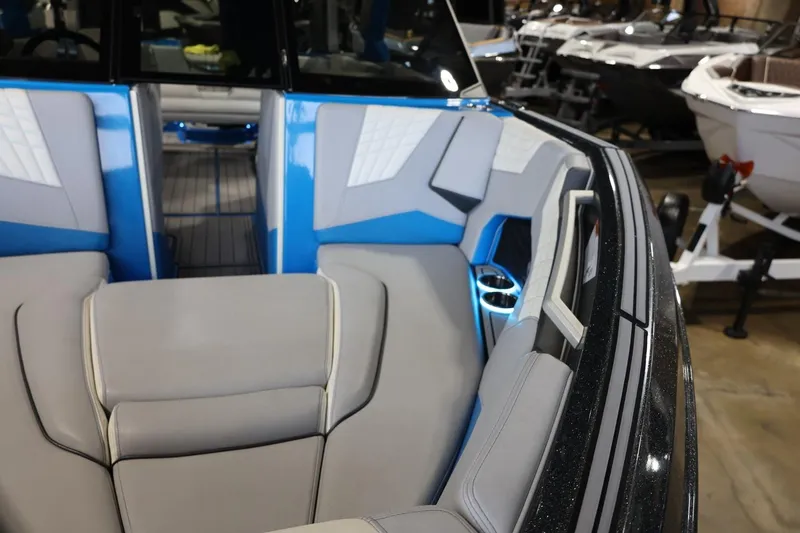 Slide: The Image of 2022 Nautique Super Air Nautique S23 boat interior with blue and gray seating. - 56
