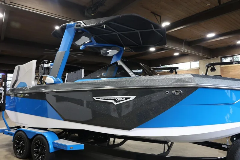 Slide: The Image of 2022 Nautique Super Air Nautique S23 boat in showroom, blue and black design. - 59