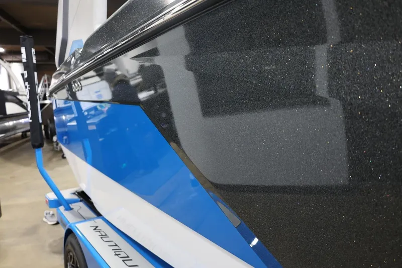 Slide: The Image of 2022 Nautique Super Air Nautique S23 boat with sleek blue and black design. - 60