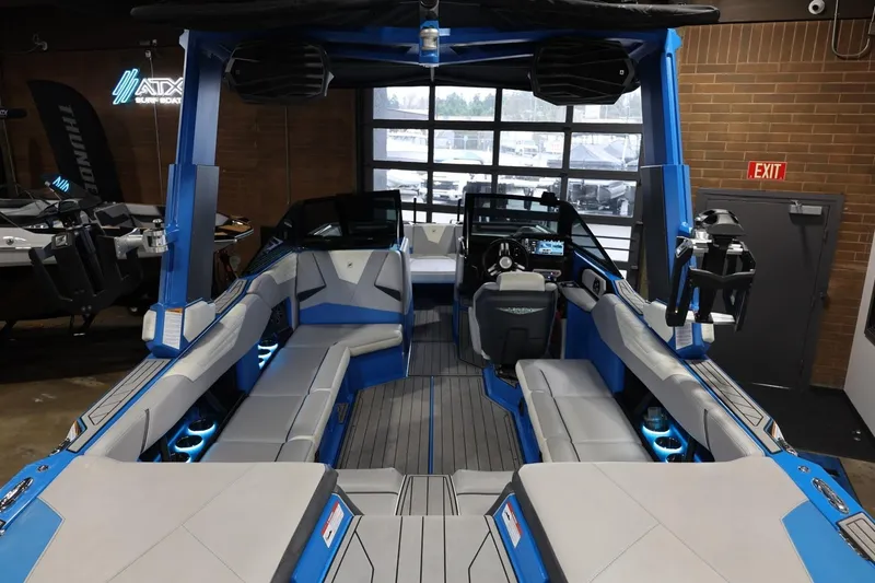 Slide: The Image of 2022 Nautique Super Air Nautique S23 interior, featuring blue and gray seating in a showroom. - 64