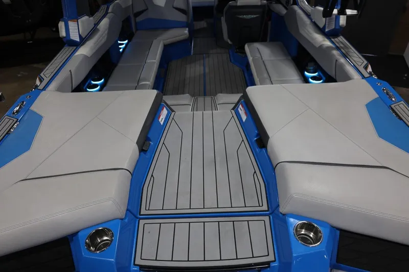 Slide: The Image of 2022 Nautique Super Air Nautique S23 interior with blue and gray seating and cup holders. - 65