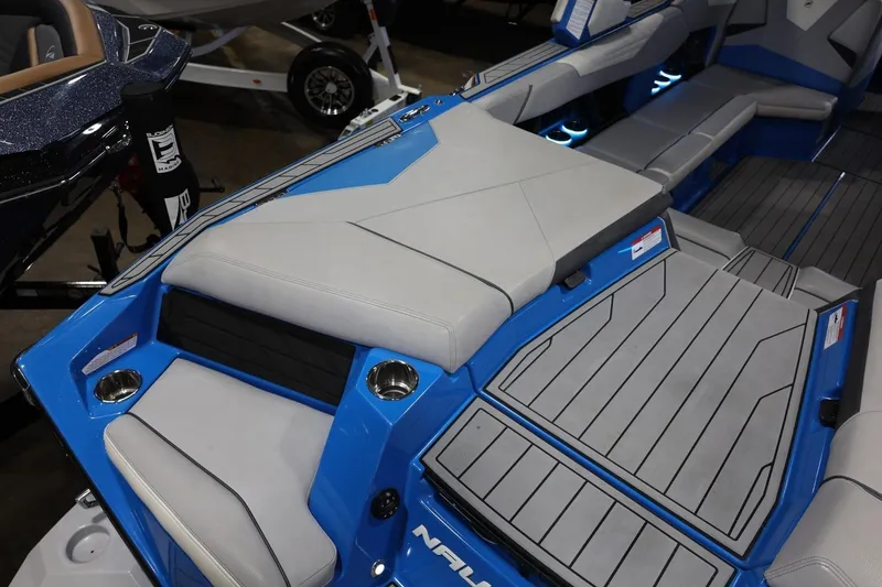 Slide: The Image of 2022 Nautique Super Air Nautique S23 interior with blue and gray seating and cup holders. - 66