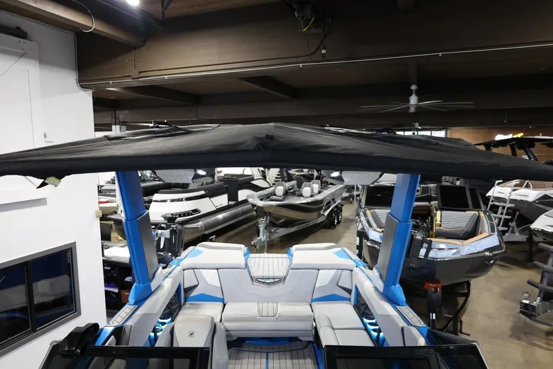 Slide: The Image of 2022 Nautique Super Air Nautique S23 boat interior with canopy in showroom. - 76