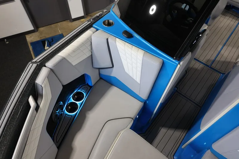 Slide: The Image of 2022 Nautique Super Air Nautique S23 interior with blue accents and illuminated cup holders. - 77