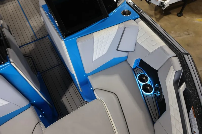 Slide: The Image of 2022 Nautique Super Air Nautique S23 interior with blue accents and cup holders. - 78