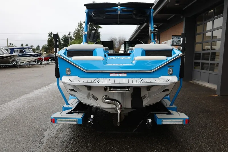 Slide: The Image of 2022 Nautique Super Air Nautique S23, blue, rear view at a dealership. - 84