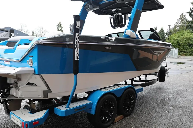 Slide: The Image of 2022 Nautique Super Air Nautique S23 boat on trailer, blue and black design. - 85